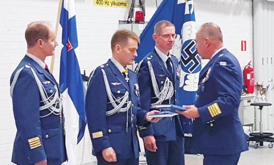 Eversti evp Ari Jussila (oik) luovuttaa kirjoittamansa historiakirjan Ilmavoimien esikuntapäällikölle prikaatikenraali Jari Mikkoselle.