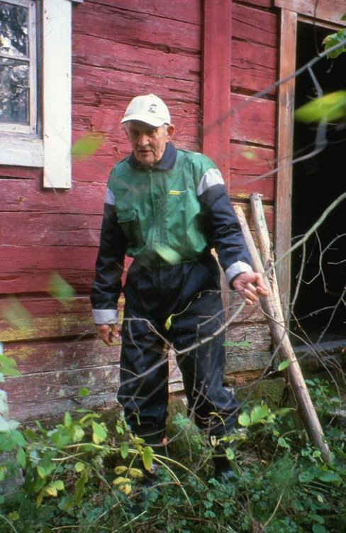 Akseli Toivonen väensaunan seinustalla. Kuva: Sirkku Pihlman 2002.
