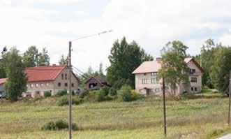 kylänraittia. Vanha asuinrakennus on sijainnut tien suutaisesti jäljellejääneen ja puretun ulkorakennuksen välissä.