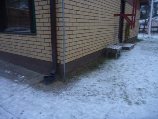 Rakennuksen sokkelia vasten ei havaintojen mukaan ole asennettu vedeneristystä, esim. patolevyä tai bitumikermiä. Salaojituksista ei tehty havaintoja. Kuva 3. Kuva rakennuksen etusivulta.