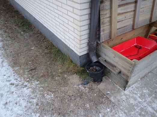 Piha-alue on sorapintainen ja tasainen tai loivasti kallellaan rakennuksesta poispäin. Kuva 4. Kuva rakennuksen takasivulta. Piha-alueen kallistus on tasainen.