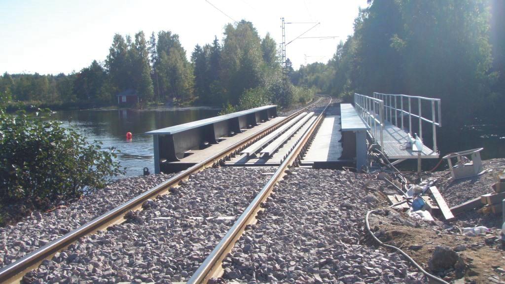 Kuva 55. Teräsrakenteinen kaukalopalkkisilta, jossa ratapölkyt ja kiskot tukeutuvat tukikerroksen välityksellä teräsrakenteeseen. Kuva 56.