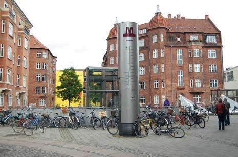 Amagerbron metroaseman logo sekä sisäänkäynnin lasikatos yms. rakennelmia. Tunneliasemille johdetaan päivänvaloa erilaisten ikkunoiden avulla. Kuva Juhana Nordlund 8.7.2008. 5 minuuttia.