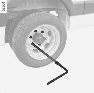 PYÖRÄN VAIHTAMINEN: hydraulinen tunkki (1/3) Irrota pyöränpultit asettamalla kuusikulmaisella jatkeella 2 varustettu rengasavain 3 (työkalukotelossa)siten, että painat sitä yläpuolelta.