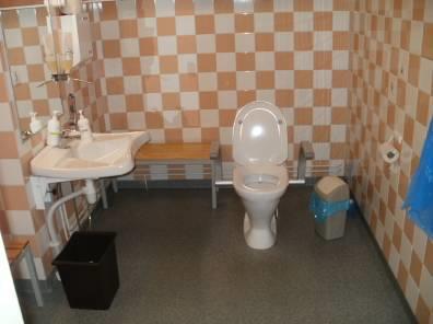 Naisten pukuhuoneen vaatekaappi Inva-wc:n edessä on loiva luiska, mikä on merkitty hyvin näkövammaiselle.
