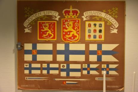 4.6. Suomen kansallissymbolit Vielä ennen poistumista tampuuriin, voi tutustua vitriinissä esiteltyihin Suomen kansallissymboleihin ja lippuihin.
