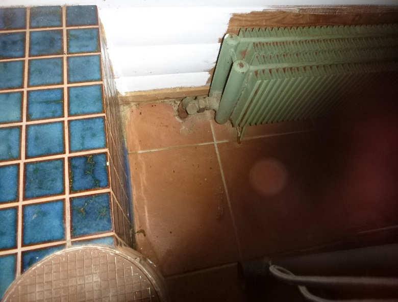 Wc-tilan edustan lattialaatat ovat irti alustastaan (ns. kopolaattoja). Laattojen saumat ovat ehjiä. Lattiakaivon kiristysrengas ja läpivientivahvike on asennettu.