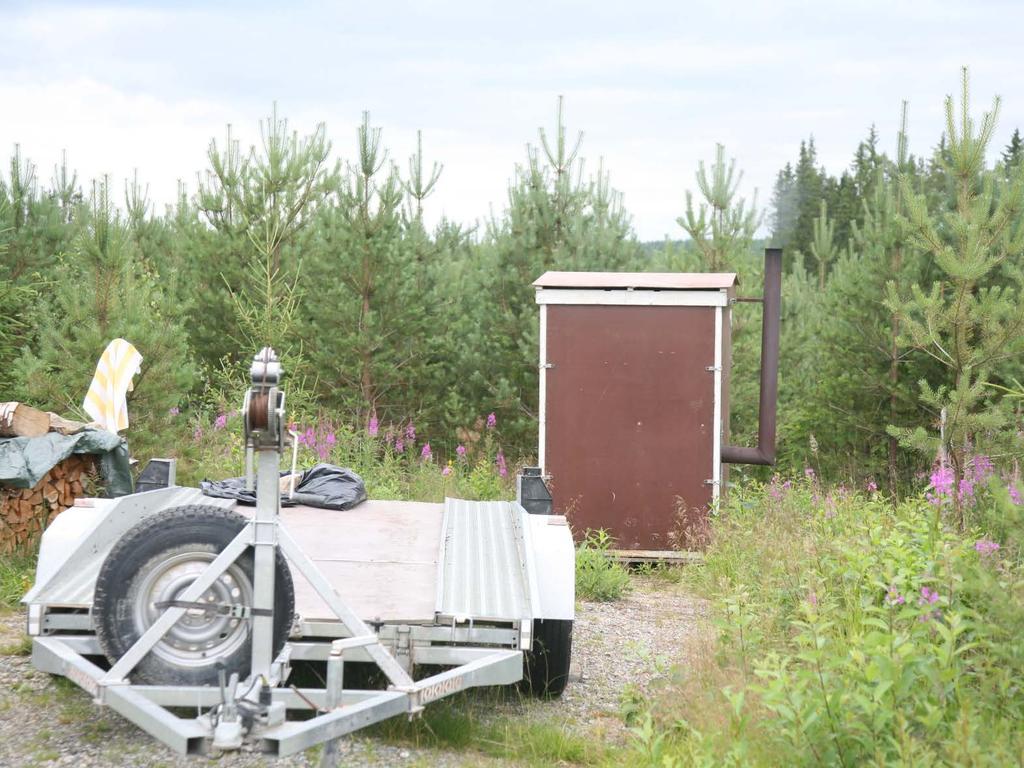 Metsurin siirtosauna lämpiää. Huomaa lavalukot, joilla seinät kiinnitetään toisiinsa. Takana näkymättömissä ikkunallinen ovi.