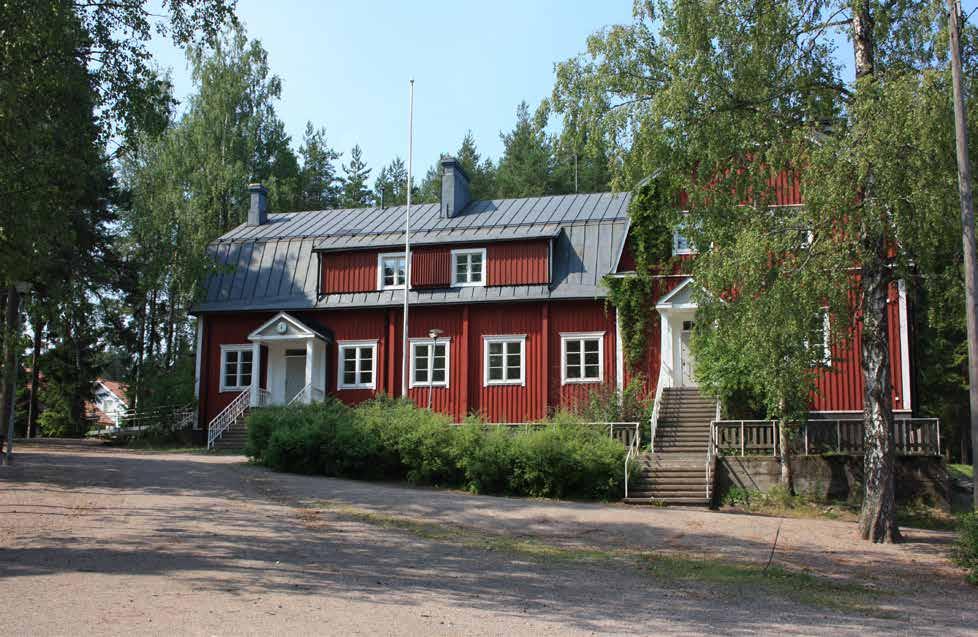 Kaksikerroksinen, hirsirakenteinen, pystyvuorattu, mansardikattoinen ja poikkipäädyllä varustettu koulutalo on sijoitettu töyräälle pihamaata hieman ylemmäksi.