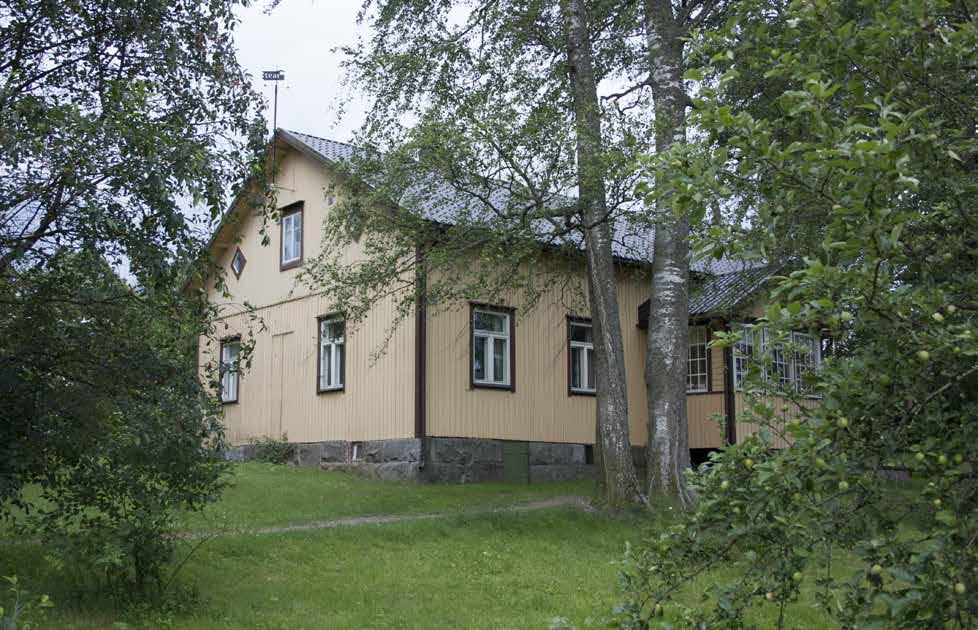 Pihapiirin eteläreunalla on uudempi asuinrakennus ja pohjoisreunalla osittain metsän peitossa korkea, punainen