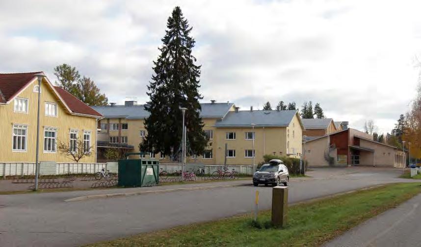 Vasemmalla puukoulu, keskellä kivisen kansakoulun opettajien
