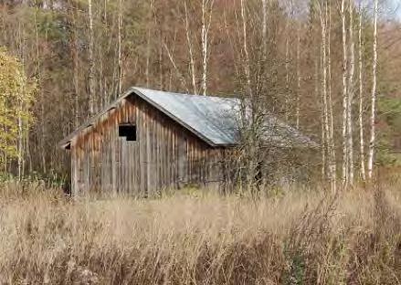 Keskellä entistä peltoa on hirsirakenteinen lato 1900-luvun
