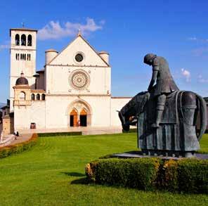 Santa Maria Maggioren kirkko Baglione-kappeleineen. Auringossa hunajanvärisinä hehkuvien talojen seinustat ja parvekkeet ovat kukkaistutusten peitossa.