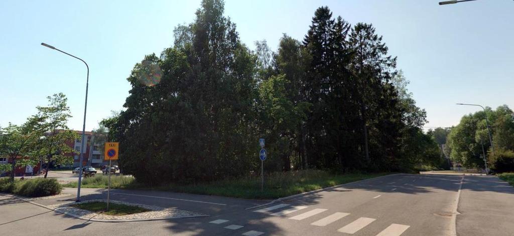 koulurakennuksesta. Suunnittelualueen itäpuolella sijaitsee parkkipaikaksi muutettu entinen postin tontti.