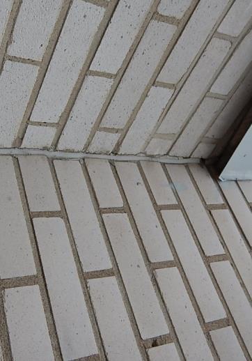 Ulkokuoren tiilimuurauksen ja mineraalivillaeristeen välissä on tuuletusrako ja laastipurseita.