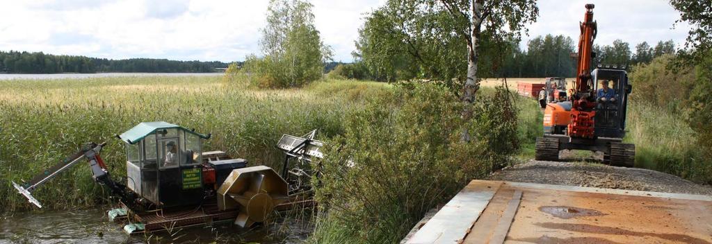 Niittokone työntää niitetyn järviruo on rantaan. Kaivuri ja peräkärry pääsevät rantaan vastaan. Vinkkejä järviruo on kustannustehokkaaseen käyttöön maanparannusaineena Mistä saa järviruokoa?