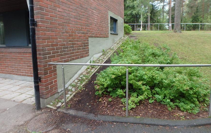 Kuva 3. Rakennuksen päädyissä on viheralueet, joiden kohdilla pintavedet ohjataan poispäin sokkelista kapealla kivetyksellä. Pinnan muotoilua on korjattu VSS:n päädyn kohdalla. 1.