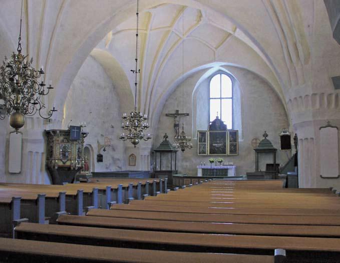 Ulvilan kirkon interiööri. Kuvassa näkyy mm. kaksi kirkossa säilyneestä 12 vihkirististä. Keskiaikaista esineistöä edustavat krusifiksi, pyhä Anna ja Olavi - veistokset 1400-luvulta.
