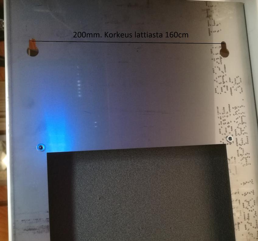 Kuva 2: Laitteen kiinnitys seinään. Taulukorttien ja taustanauhan asennus Laitteen ampumakuntoon saattaminen on helpoin tehdä seuraavassa järjestyksessä: 1.