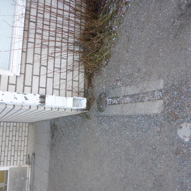 Rakennuksen länsipuolella (koulun piha-alueen puolella)